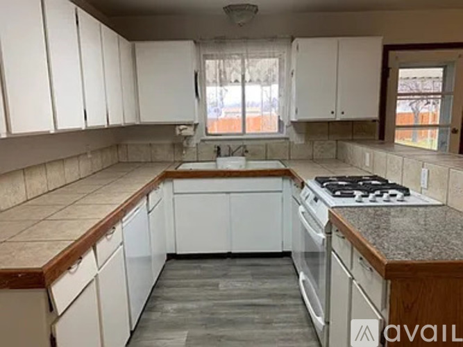A kitchen with white cabinets and a granite countertop.