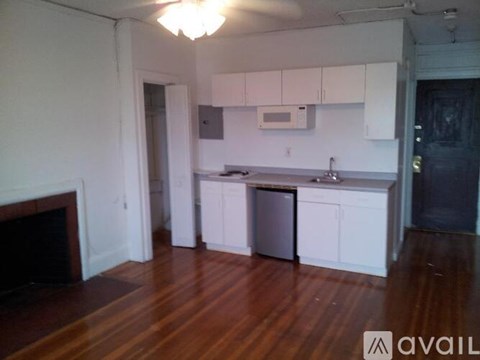 A kitchen with white cabinets and a wooden floor.