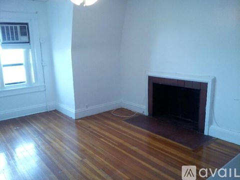 A room with a fireplace and wooden floors.