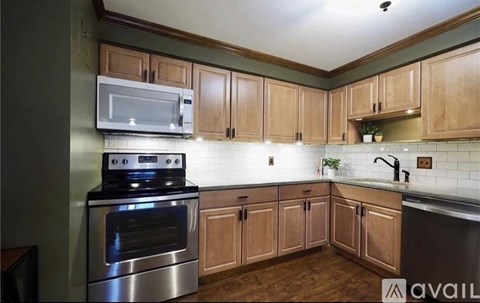 A kitchen with wooden cabinets and a stainless steel oven.