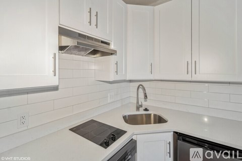 A kitchen with white cabinets and a stove top oven.
