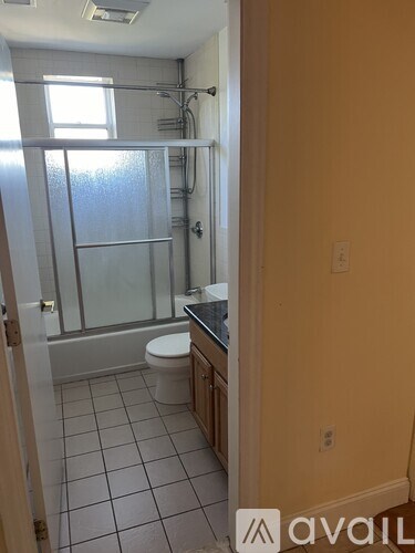 A bathroom with a toilet, sink, and shower.
