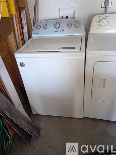 A white washing machine and dryer are sitting next to each other.