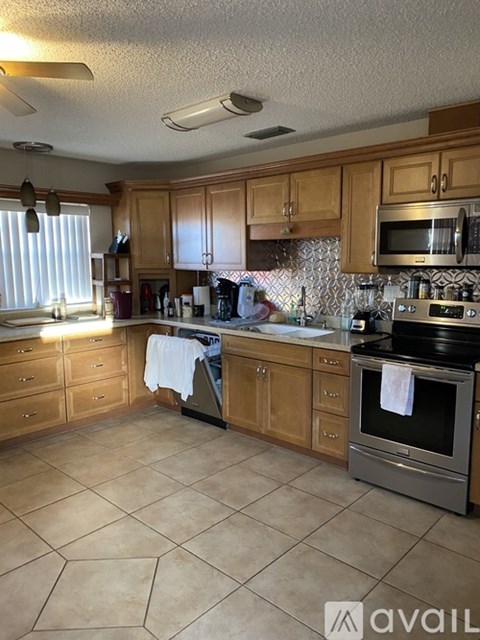 A kitchen with wooden cabinets and a tiled floor.