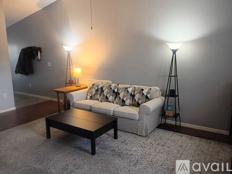 A living room with a couch, coffee table, and two lamps.