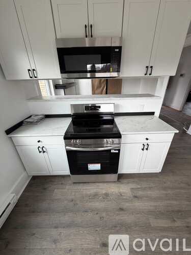 A kitchen with white cabinets and a black stove top oven.