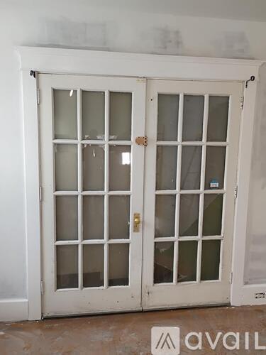A white double door with glass panels and a gold handle.