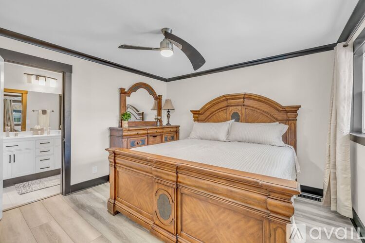A bedroom with a large bed and a dresser with a mirror.