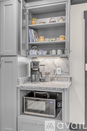 A kitchen with a microwave oven and a coffee maker on a countertop.