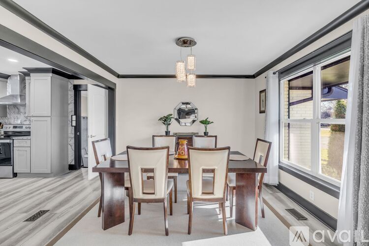 A dining room with a wooden table and chairs.
