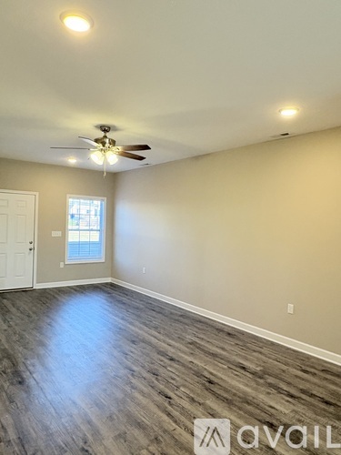 A spacious kitchen and living room with wood flooring.
