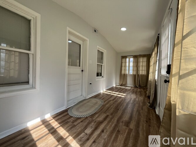 A hallway with wooden floors and white walls.