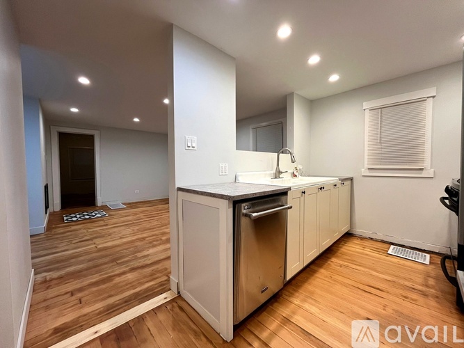 A kitchen with wooden floors and white walls.