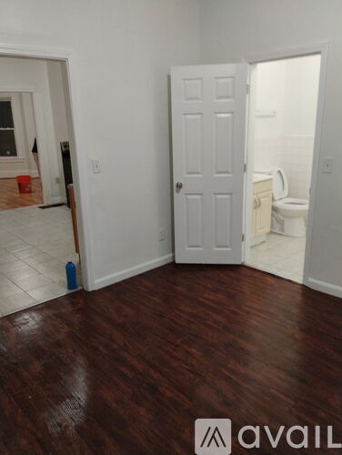 A room with a wooden floor and a white door.