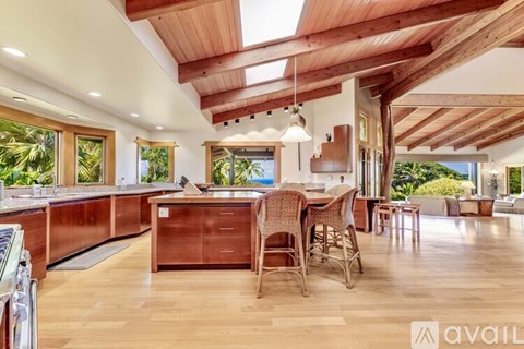 A modern kitchen with wooden cabinets and a dining table.