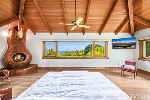 A bedroom with a large bed and a fireplace.