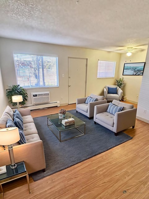 A living room with a glass coffee table and two couches.