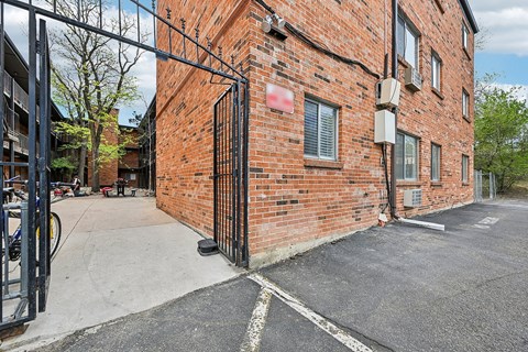 A red brick building with a black gate in front.
