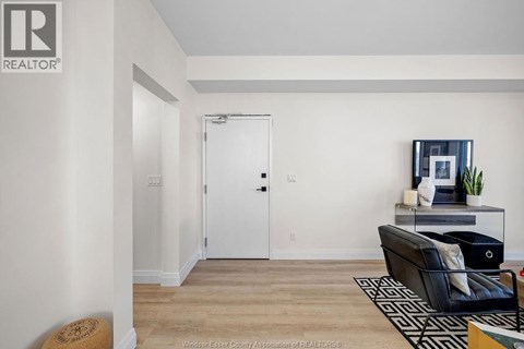 A living room with a black couch and a white door.