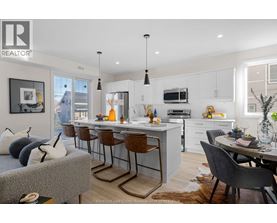 A modern kitchen with a dining table and chairs.
