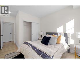 A bedroom with a bed, pillows, and a blanket.
