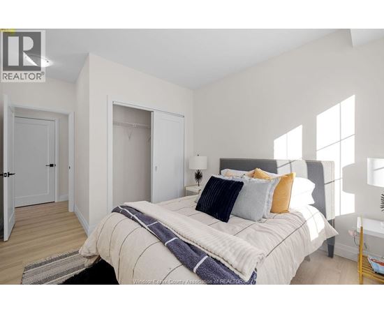 A bedroom with a bed, pillows, and a blanket.