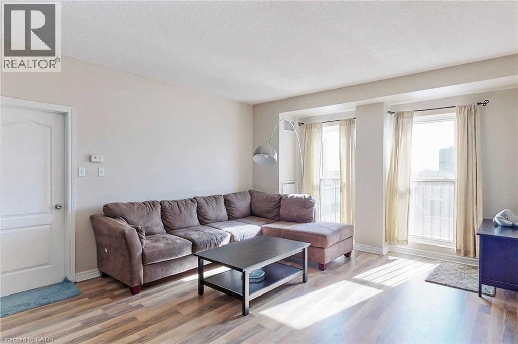 A living room with a brown couch and a glass coffee table.