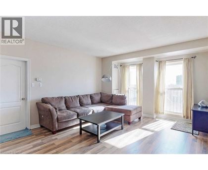 A living room with a brown couch and a glass coffee table.
