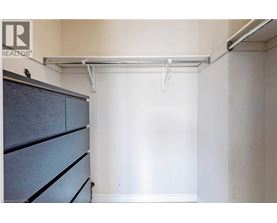 A bedroom with a bed and a cabinet.