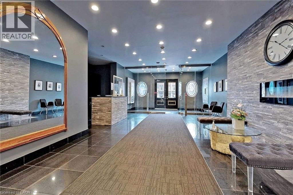 A spacious lobby with a long wooden floor and a large clock on the wall.
