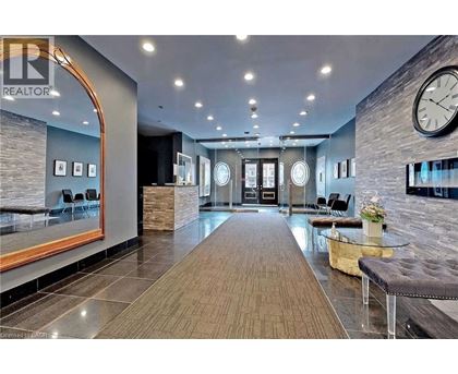 A spacious lobby with a long wooden floor and a large clock on the wall.