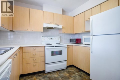 A kitchen with wooden cabinets and white appliances.