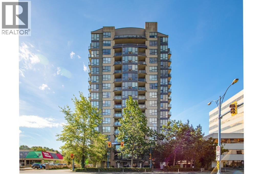 A tall residential building with a clear blue sky above it.