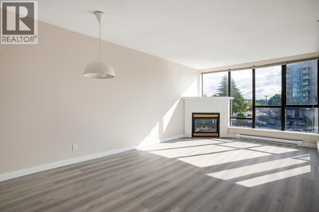A large, empty room with a fireplace and a large window.