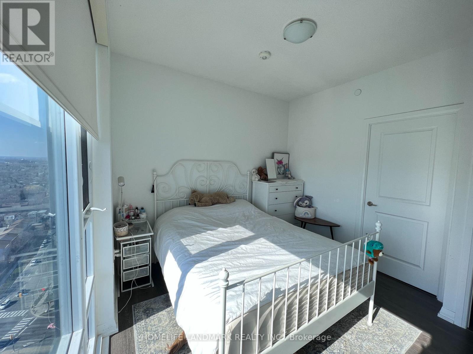 A bedroom with a large bed and a view of the city.