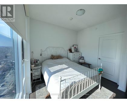 A bedroom with a large bed and a view of the city.