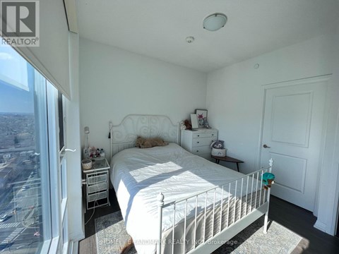 A bedroom with a large bed and a view of the city.