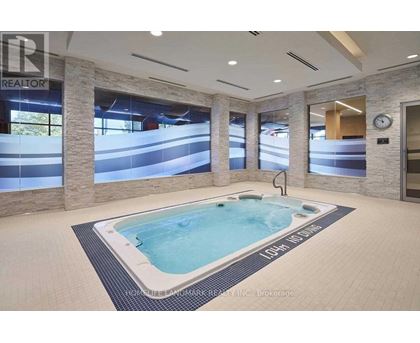 A hot tub in a room with a clock on the wall.
