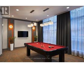 A pool table in a room with a television and a plant.