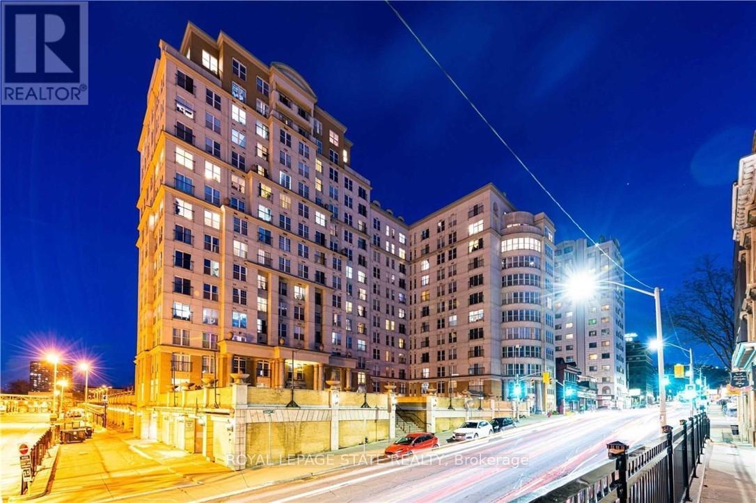 A nighttime city street with a tall building and a REALTOR sign.