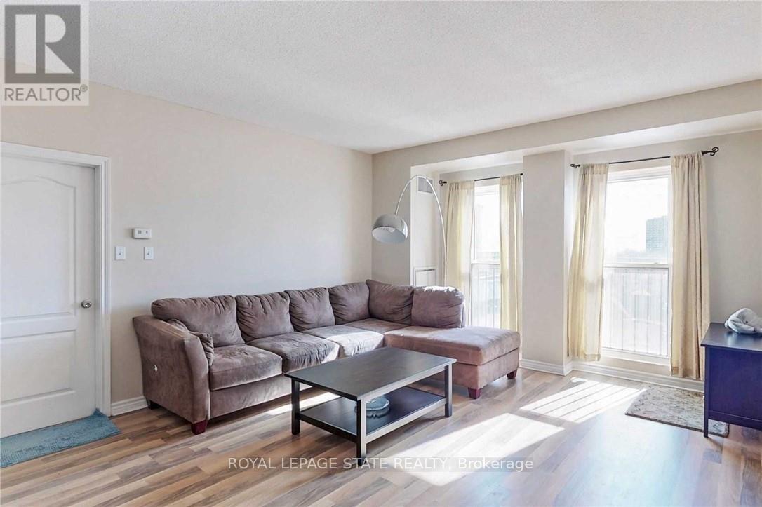A living room with a brown couch and a glass coffee table.