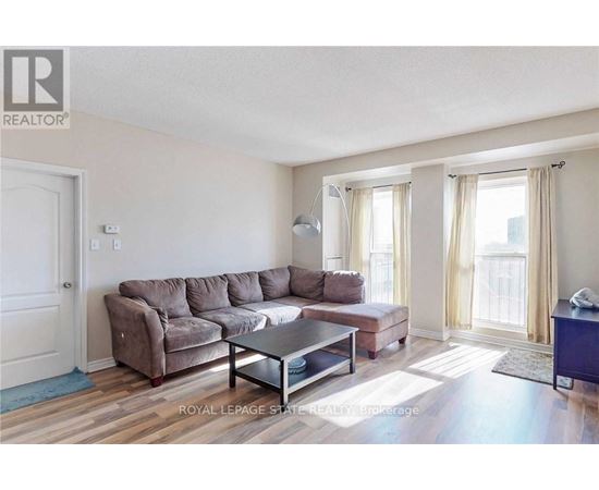 A living room with a brown couch and a glass coffee table.