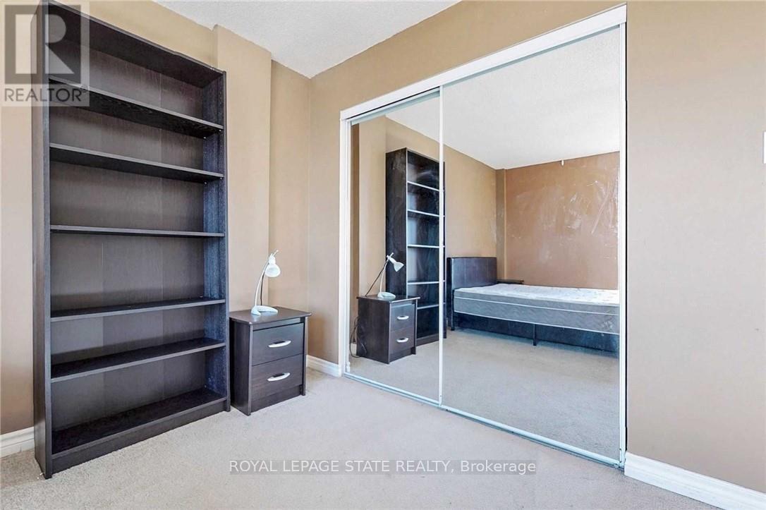 A bedroom with a large wardrobe and a bed in the other room.