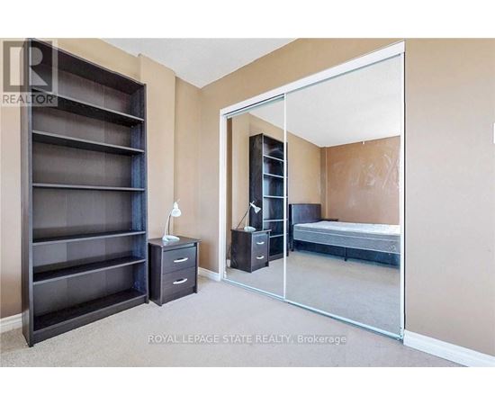 A bedroom with a large wardrobe and a bed in the other room.