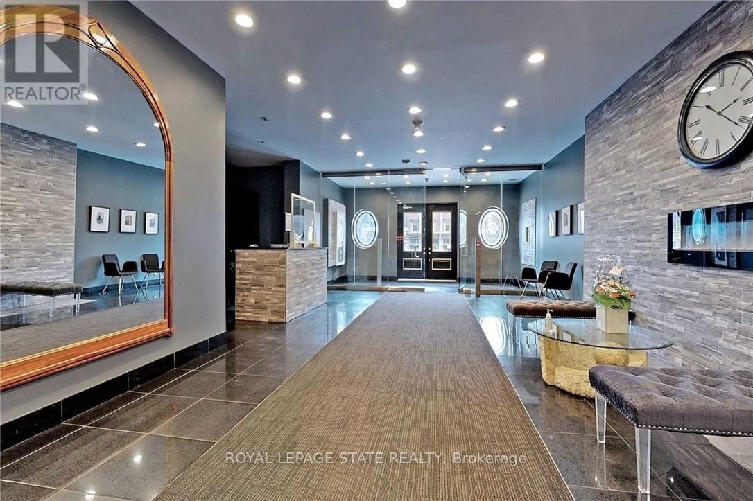 A spacious lobby with a wooden floor and a large clock on the wall.