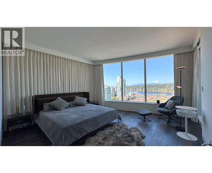 A bedroom with a large bed and a view of the city.
