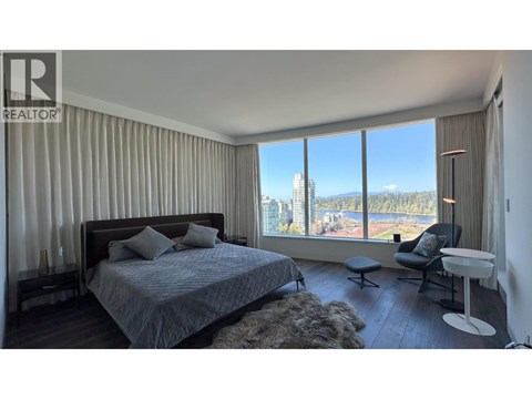 A bedroom with a large bed and a view of the city.