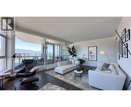 A living room with a white couch and a black chair.