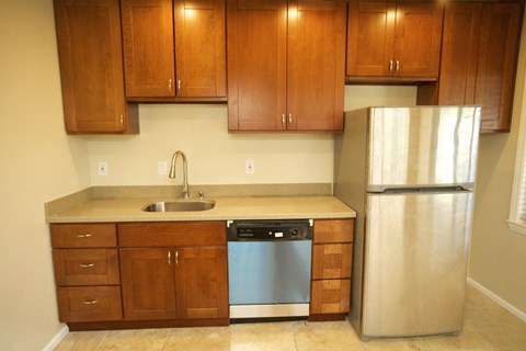 a kitchen with wooden cabinets and a stainless steel refrigerator