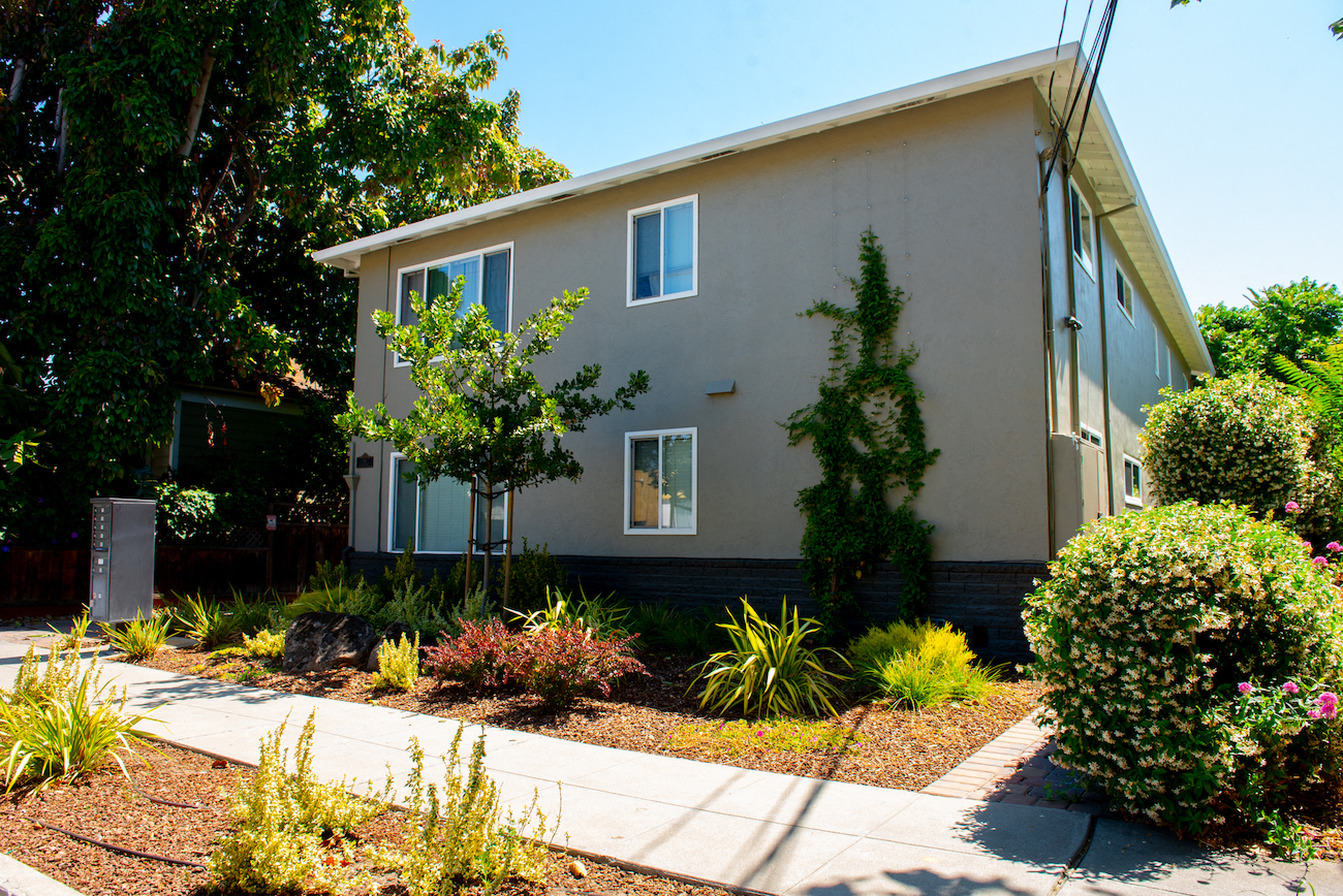a white house with a garden in front of it